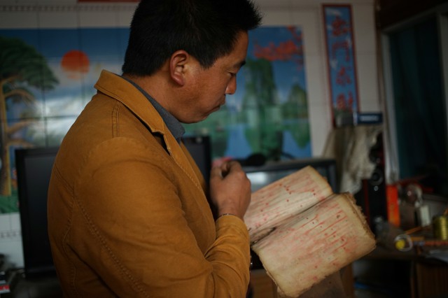 这位彝族青年在政府鼓励下学习彝文.jpg